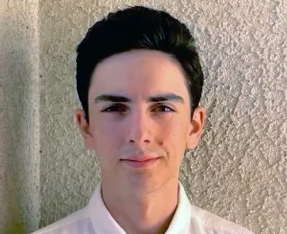 A young man with dark hair and wearing a white shirt.